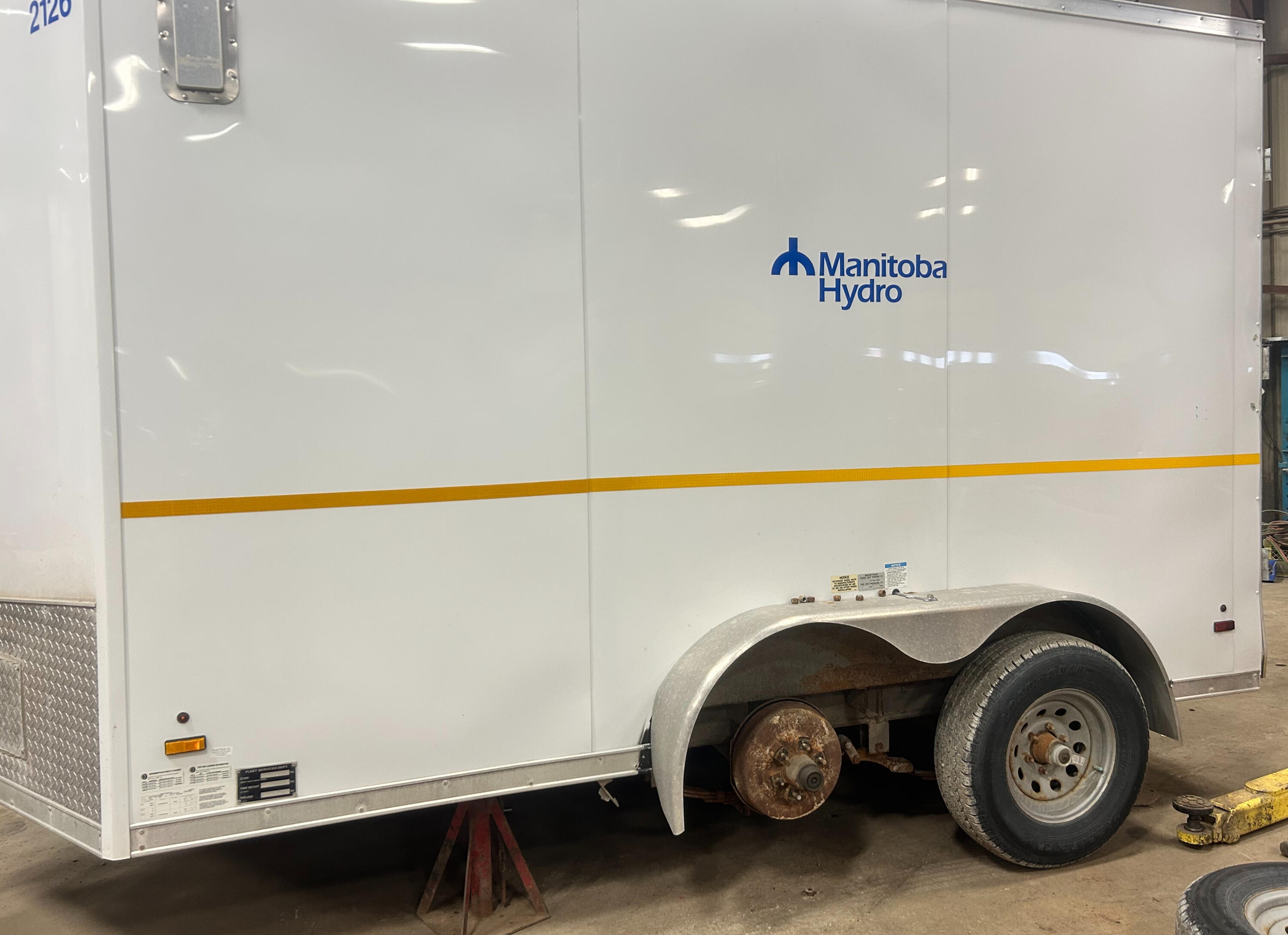 Trailer Suspension & Axle Service | Standard Auto Spring Works Winnipeg Commercial enclosed trailer receiving suspension and axle repairs at Standard Auto Spring Works in Winnipeg, Manitoba. Trailer axle replacement, leaf spring repair, wheel bearings, U-bolts, and suspension service.
